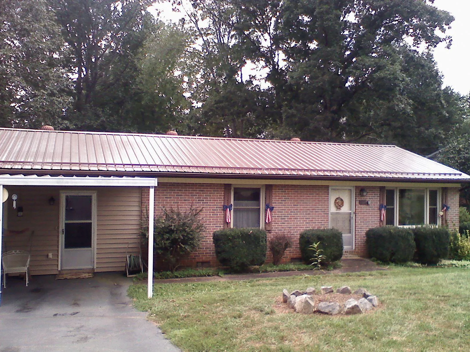 Bronze metal roof and carport on a brick ranch home — Roof Repair work by our crew in Whittier